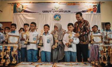 Siswa SD Islam berprestasi di Jogja sedang menerima piala penghargaan lomba dari guru dengan bangga di sekolah
